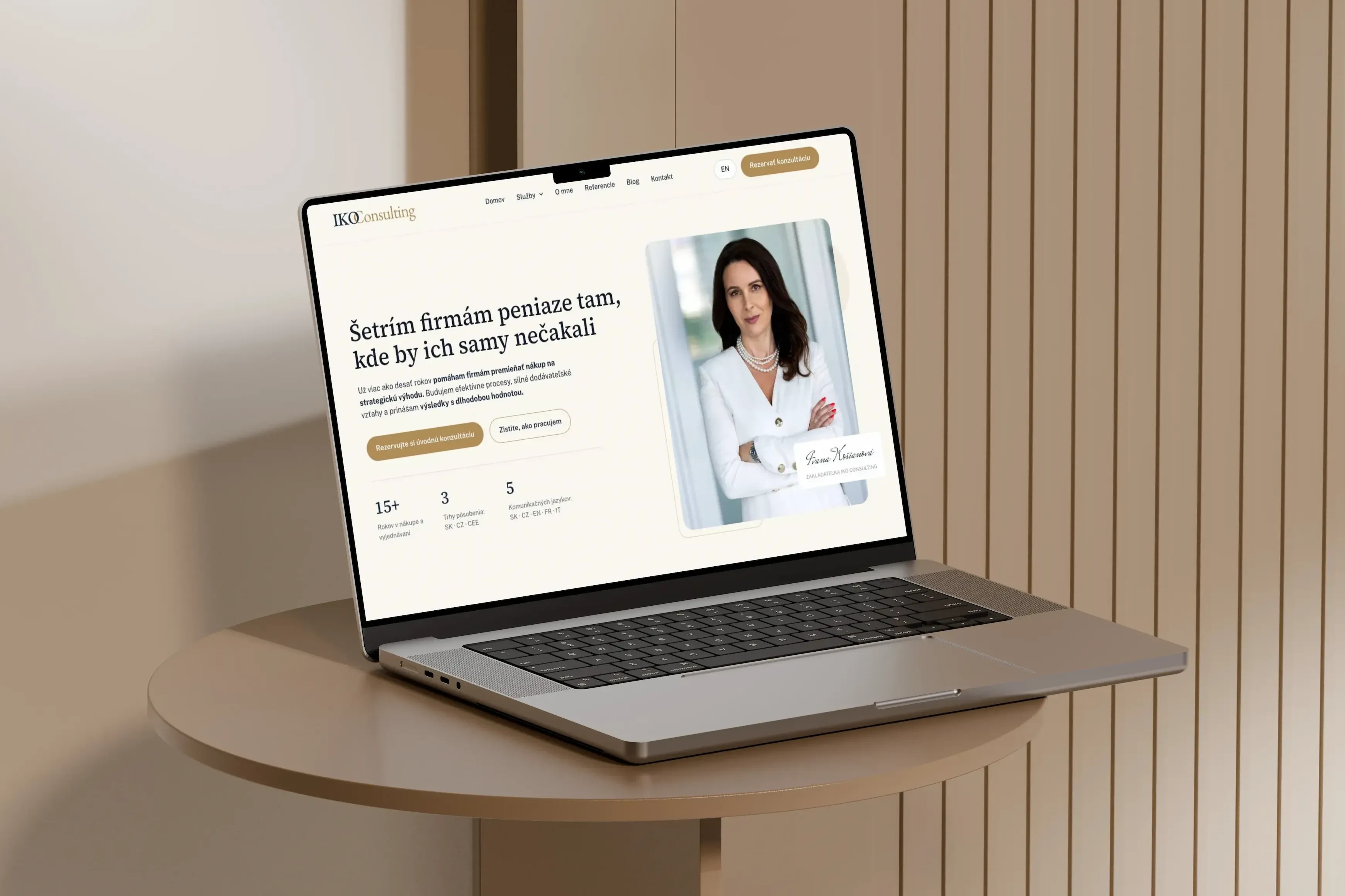 Web ikoconsulting.sk na MacBooku, béžovo-zlatý hero s portrétom zakladateľky a headline „Šetrím firmám peniaze tam, kde by ich samy nečakali“